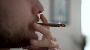 Man with beard smoking a thin cigar indoors - Free Stock Video