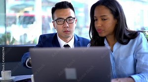 Successful diverse young man and woman dressed in formal wear watching business webinar on website on laptop computer during meeting in cafe.Collaborative process on creating database on computer