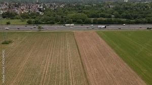 Many cars and trucks driving in different directions on the German Autobahn on an overcast day. Approaching aerial side view