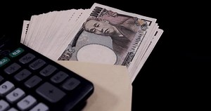 A bundle of bills by Japanese old banknotes with a envelope with calculator panning