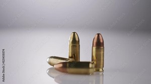 Gun Control. Ammunition of 9mm bullets rotating on a reflective surface