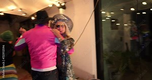 This lively footage captures the essence of a festive celebration as senior couples whirl around the dance floor with gusto. Dressed in vivid, colorful attire, they embody the spirit of joy and Stock Video