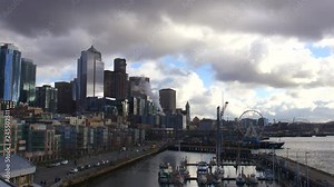 UHD 4K time lapse video of moving clouds and sky over downtown cityscape and waterfront pier 66 along Elliot Bay in Seattle Washington 3840x2160 Ultra High Definition