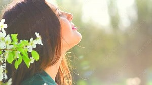 Beauty young woman enjoying nature in spring apple orchard, Happy beautiful girl in garden with blooming trees. Slow motion 4K UHD video footage. 3840X2160