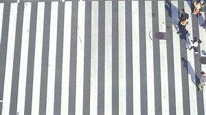 A pedestrian crossing the crosswalk at the intersection of Tokyo, Japan
