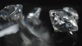 Shiny classic shape diamonds on black surface and background. Camera...