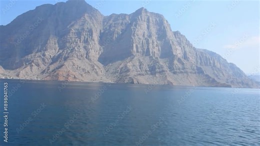 Aerial View of Musandam Peninsula Fjords at the Strategic Strait of Hormuz. overlooking the narrowest point of the Strait of Hormuz. This "Norway of Arabia" serves as the southern gateway to the Persi