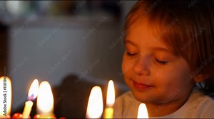 Candlelit Birthday Wish: A child with eyes closed, making a wish before blowing out the candles on their birthday cake, with the soft candlelight reflecting in their happy expression.