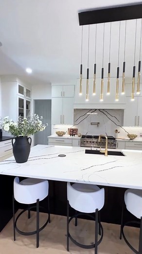 MSI Surfaces on Instagram: "Simplicity and style come together in this kitchen transformation! Our Calacatta Laza Night countertop, used as a waterfall island and backsplash, creates a striking monochrome look with its bold veining on a cool white background. Ideal for those seeking a modern, marble-inspired option for clients. Credit: @marblegraniteworld & @wdcustomhomes"