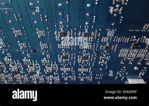 Complex blue printed circuit board displays detailed electronic microchips and bright silver solder joints. Shallow depth of field highlights the intricate pathways of modern hardware Stock Video Footage - Alamy
