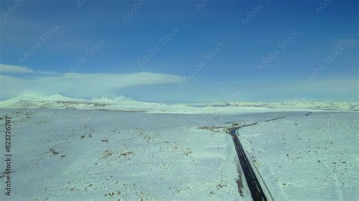 Experience the majestic Volcanoes Viewpoint with Sabancaya Volcano in the backdrop. Aerial drone captures the pristine white landscape, revealing surrounding mountains and winding roads in this stunn