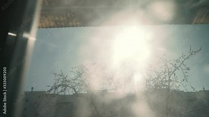 4K Sun shines through window under ceiling. Room, outside the windows street, sunny sky, trees, houses. Slow motion. 3840x2160