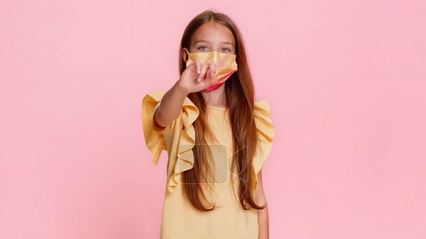 Little child girl fearfully shows a stop gesture while wearing a medical mask, then removes it and smiles with visible relief. School kid on pink background, portraying transition from fear to joy Stock Video Footage - Alamy
