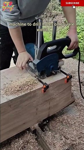 A carpenter uses a portable mortise and tenon machine to drill holes on square wood
