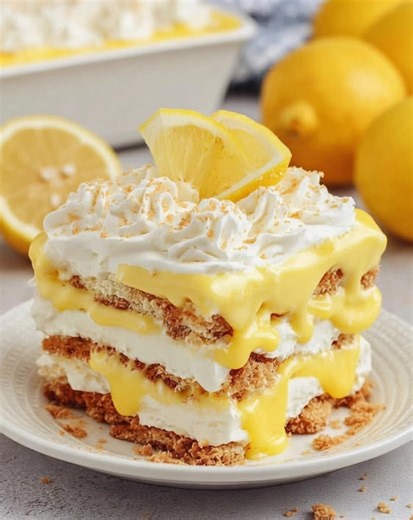 🍋🍰✨ Lemon Icebox Cake Cool, Creamy & No-Bake Sunshine 💛 This Lemon Icebox Cake is a bright, refreshing dessert layered with silky lemon pudding, fluffy whipped topping, and classic graham crackers. As it chills, the layers soften into a sliceable, cake-like treat that’s light, creamy, and perfect for warm days, potlucks, or easy entertaining. Ingredients Lemon Cream Layer • 6.8 oz lemon instant pudding mix (2 boxes) • 3 cups whole milk • 8 oz whipped topping Assembly • 14.4 oz graham crackers