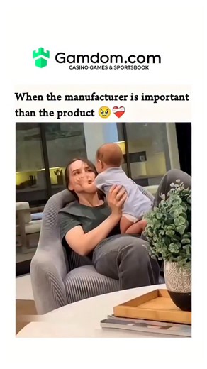 Entertainment Glmr on Instagram: "The video shows a woman sitting in a chair, holding her baby upright on her lap. The Interaction: The baby leans in and gives the mother a big, open-mouthed "kiss" or nuzzle on the cheek. The Reaction: The mother looks directly at the camera with a playful, mock-emotional expression—her bottom lip is turned out as if she’s about to cry from how cute (or slobbery!) the moment is. The Punchline: The text overlay reads, "When the manufacturer is important than the
