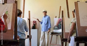 Elderly people painting for hobby. Group of active seniors at art school. Leisure activity, lifestyle, recreation, passion. Old man at work as teacher, teaching technique to students. Slow motion