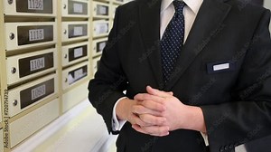 Concierge standing at mailboxes and twiddle thumbs