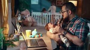 Multitasking father comforts a crying newborn baby by rocking her in his arms, while in the background his 3-year-old sons are playing in the crib Stock Video