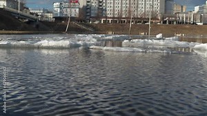 the flood of the river after the snow melts. running ripples on the water. ice floes of snow melt in the spring sun
