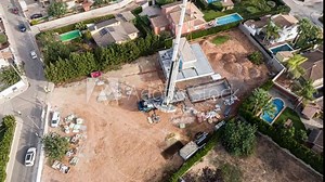 Hyperlapse of crane stacking modules for construction of prefabricated building. Aerial top-down orbiting
