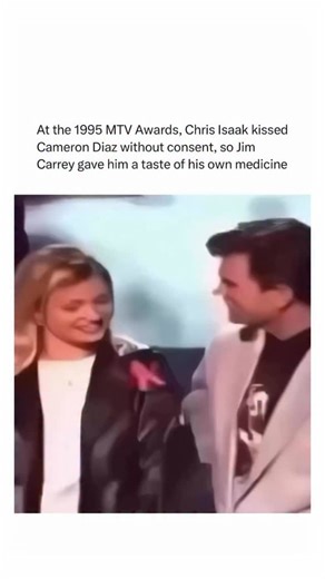 Worlds Wildest Moments on Instagram: "A moment from the 1995 MTV Movie Awards that’s since gone down in pop-culture history. While presenting onstage, musician Chris Isaak unexpectedly kissed actress Cameron Diaz. Moments later, co-presenter Jim Carrey turned the tables in front of the live audience, playfully giving Isaak “a taste of his own medicine.” The unscripted exchange caused a stir at the time and has since been replayed as an example of the unpredictable, chaotic energy of mid-90s awar
