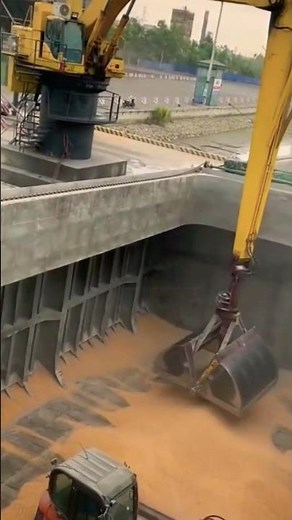 The crane uses a grab bucket to lift and move materials.