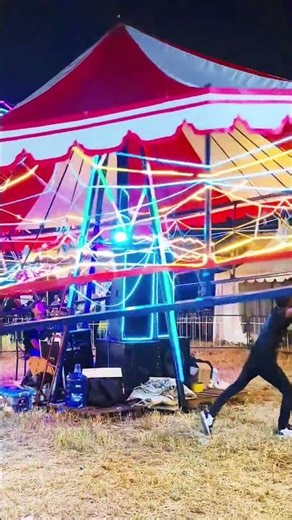 Children riding carousel under neon carnival lights #carousell #carnival