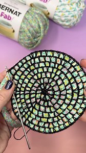 Coiled crochet is a technique that allows you to crochet around a coiled piece or yarn or rope. It’s the perfect technique to use with our new Bernat Fab yarn. Pair it with a black cotton thread to create almost a stained glass, or mosaic-like look. Grab the Bernat Fab yarn: https://bit.ly/4oSoUzV Thread: Aunt Lydia’s Size10 Classic Cotton Tools: Susan Bates Silvalume 2.35 mm hook | Bernat Yarn