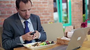 Businessman receiving phone call during lunch in cafe