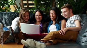 Friends sitting and using laptop on the couch
