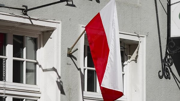 Polish flag waving mounted on building wall in slow motion. Symbols of European countries, historical and state values. Polish Independence Day