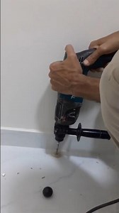 Drilling a hole in ceramic tile floor with a jackhammer
