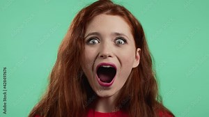 Pretty woman is very glad, she screaming WOW loud. Concept of sales, profitable offer. Excited happy lady on green studio background.