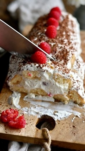 Pyszna i szybka w przygotowaniu rolada biszkoptowa z malinami! 😍 Składniki (około 8 części): 250 g serka mascarpone 2 łyżki cukru pudru 300 g śmietanki 30% 14 biszkoptów (140g) podłużnych 100 ml mleka (może być smakowe, np. waniliowe) 100 g malin maliny do ozdoby 1 kostka czekolady do starcia Serek mascarpone miksujemy z cukrem pudrem i śmietanką na gładki krem. Biszkopty maczamy w mleku i układamy na foli spożywczej jeden obok drugiego (dwa rzędy po 7 biszkoptów). 2/3 kremu wykładamy na biszko