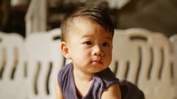 Asian baby boy having fun crawling on floor at home
