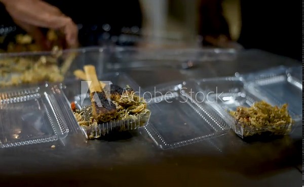Plating delicious Balinese traditional food, which has fish satay with grated coconut, and choped spicy steamed young jack fruit for vegetables.