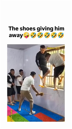 @ClipoGram on Instagram: "- The video depicts a chaotic group game in a colorful foam-mat room, likely from a Chinese variety or team-building show, where blindfolded participants use a stick with a yellow object to tag others while climbing through a small window obstacle. - Bright yellow Crocs-style shoes comically protrude from hiding spots and the window, instantly revealing participants' positions and sparking the post's punchline, amplified by exaggerated physical comedy and failed stealth