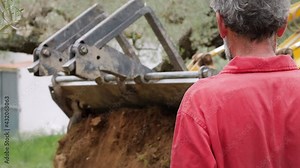 Farmer watching a Excavator working in a field of a Farm. Backhoe operating in a Land on The Nature