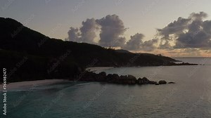 Glowing skies after sunset. Island silhouette, sandy beaches, serene ocean, fluffy cloud, Seychelles Africa. Civil twilight, afterglow, Breathtaking view of a remote mountainous island before sundawn.