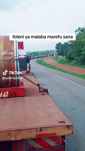 Large Red Truck Transporting Heavy Metal Object