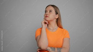 Young woman thinking to solve a problem. Isolated girl thoughtfully at idea hold hand to chin with gesture of thought about problem solution with puzzled facial expression close up. Decision concept.