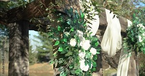 Beautiful wedding arbor with white draping cloth, white rose bouquets with a pond and woods in the background in Ottawa, Ontario (Bean Town Ranch).