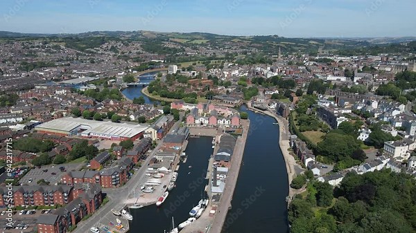 Aerial footage of Exeter Quay, Devon, England, showing the historic waterfront along the River Exe with charming buildings, boats, and vibrant surroundings. Ideal for travel, urban, and historic uses.