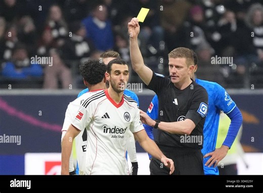 31 January 2026, Hesse, Frankfurt/M.: Soccer: Bundesliga, Eintracht Frankfurt - Bayer Leverkusen, Matchday 20, Deutsche Bank Park. Ellyes Skhiri (Eintracht Frankfurt) has received a yellow card from referee Robert Schröder (Hannover). Photo: Marc Schüler/dpa - IMPORTANT NOTE: In accordance with the regulations of the DFL German Football League and the DFB German Football Association, it is prohibited to utilize or have utilized photographs taken in the stadium and/or of the match in the form of 