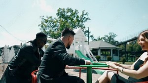 A group of adults play on the playground and laugh like children.Adults play on a children's swing.The concept of nostalgia for childhood