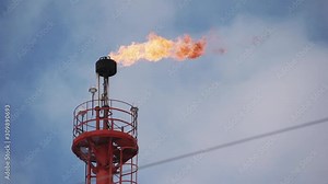 fume of fire on flare stack to burning heat gas, pollution in environment concept, for power and safety in petrochemical, chemical refinery or power plant in industrial zone, blue sky