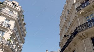 Bottom view footage of old, traditional buildings in Paris. It shows Parisian and French architectural style. It is a sunny summer day.
