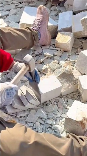Manual stone chiseling technique shaping limestone blocks for construction craftsmanship