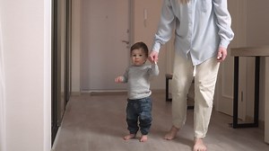 Free stock video - Mother helps her baby to get up from the floor and take his first steps at home